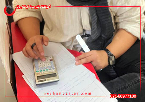 هنرجو در حال کار با ماشین حساب در دوره اموزش حسابداری برای کسب دیپلم حسابداری