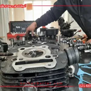 اجزای باز شده موتورسیکلت روی میز کارگاه در دوره آموزش تعمیر موتورسیکلت