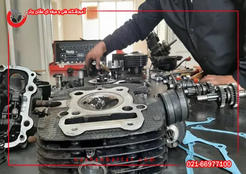 اجزای باز شده موتورسیکلت روی میز کارگاه در دوره آموزش تعمیر موتورسیکلت