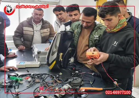 هنرجویان دوره آموزش تعمیرات موتورسیکلت در حال آموزش و کار با دستگاه مولتی متر و تست قطعات برقی در کارگاه آموزشگاه تعمیر موتورسیکلت نشان برتر