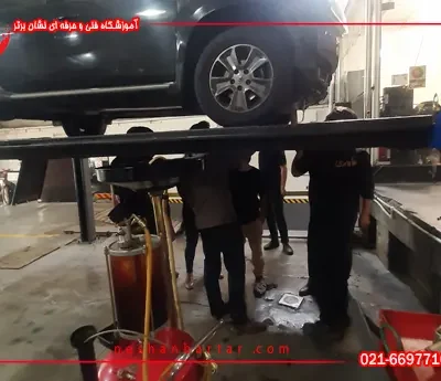 هنرجویان دوره تعویض روغنی در حال اموزش تعویض روغن و سرویس های دوره ای خودرو های خارجی در کارگاه مجهز اموزشگاه فنی و حرفه ای تعویض روغنی نشان برتر