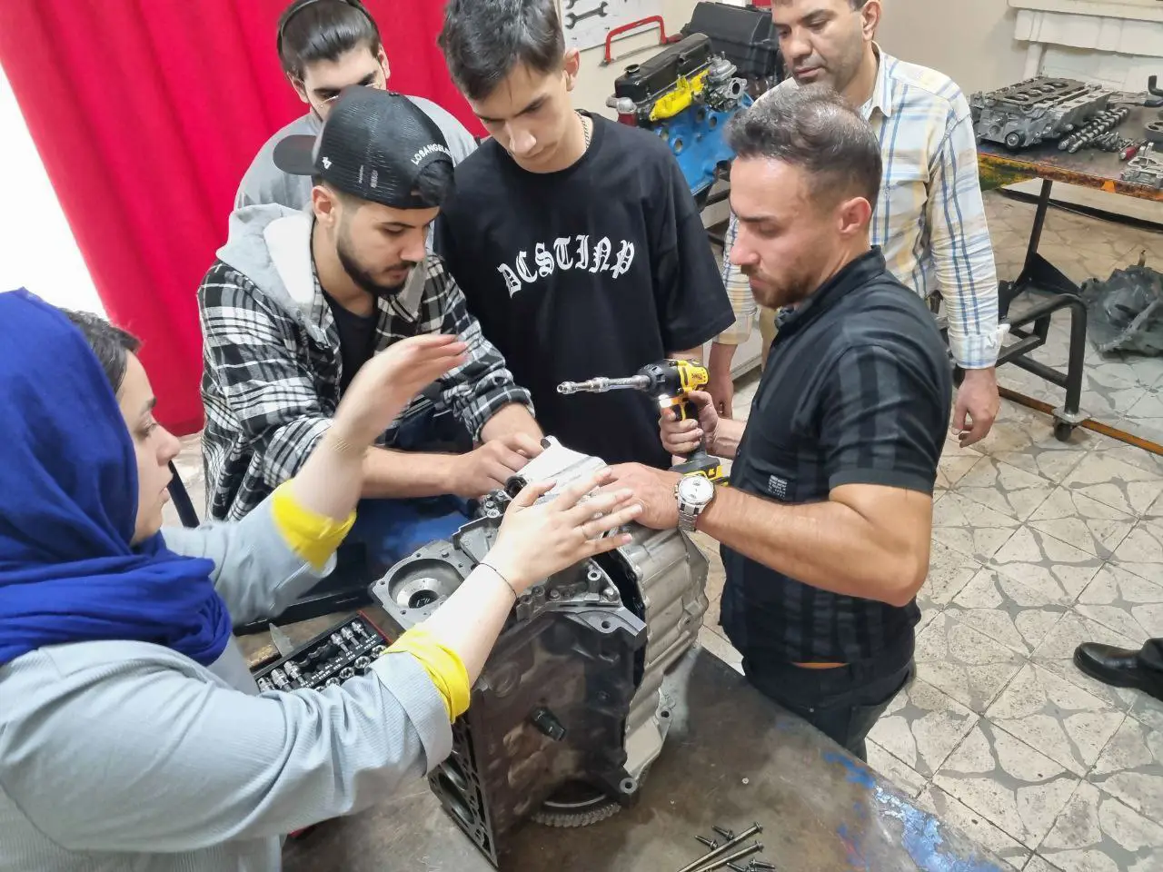 هنرجویان در حال آموزش مکنیک خودرو در آموزشگاه مکانیک خودرو